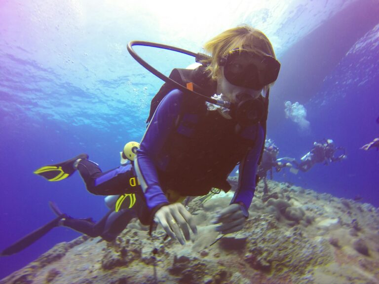 Thrilling underwater scene with scuba divers exploring vibrant coral reefs.